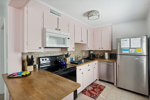 This kitchen includes large modern appliances in a vintage setting with a beautiful tiled floor and expertly tiled backsplash.