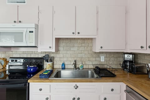 This kitchen includes large modern appliances in a vintage setting with a beautiful tiled floor and expertly tiled backsplash.