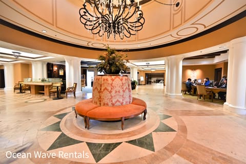 Elegant lobby with chandelier, refined seating, and marble flooring.