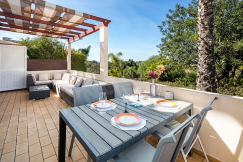 Covered terrace with outdoor dining area at Boa Nova apartment, Algarve