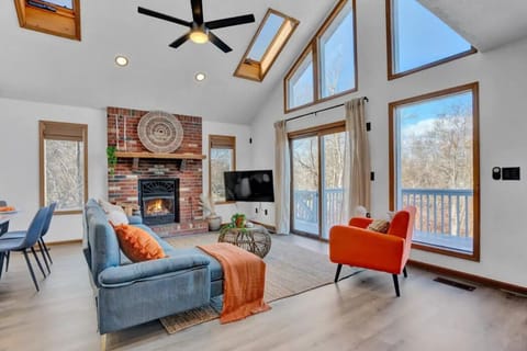 Living room space with fireplace & ceiling to floor windows.