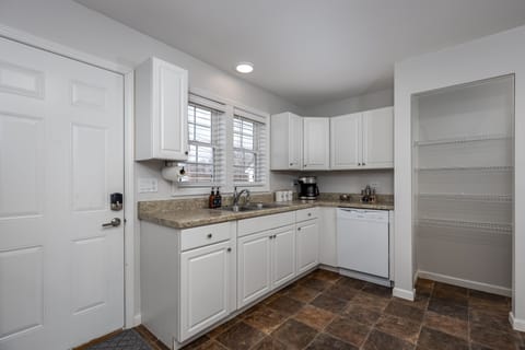 Kitchen has a dish washing machine and a machine brewer & French press.