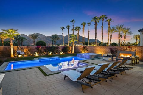Evening poolside glow w/ mountain backdrop, lounge chairs & a calm, inviting vibe