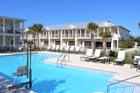 Large pool with lounge chairs and tables.