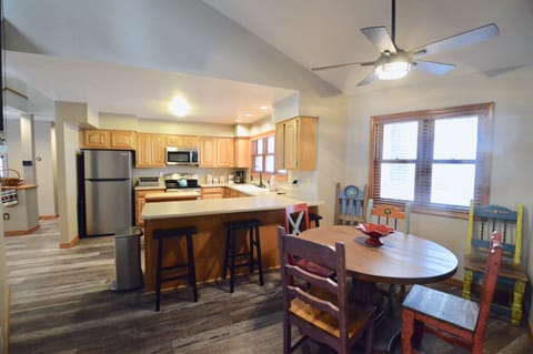 Breakfast nook with large TV, counter with barstools, new appliances in kitchen
