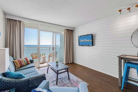 Unwind in this coastal-inspired living room with cozy seating, charming decor, and floor-to-ceiling views of the ocean. Step onto the balcony to feel the sea breeze or relax indoors with all the comforts of a stylish beachside retreat.