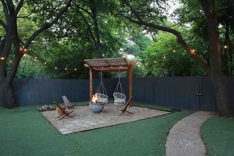 Beautiful spacious back yard with fire pit and swings and seating area for family fun