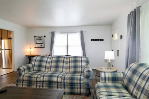 Living area with couch, love seat, sitting chair, bench, and 50" smart tv.