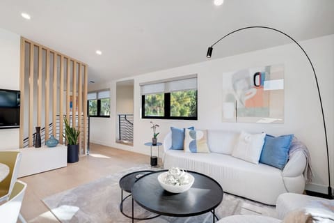 Relax, dive into a captivating book, or enjoy your favorite TV program in this sunlit, minimalist designed living room, equipped with a 55-inch TV