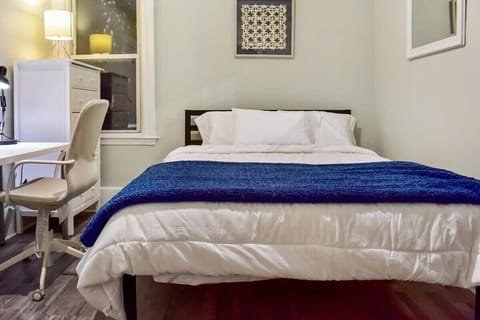The rear bedroom features a dresser, desk, queen bed, and large closet
