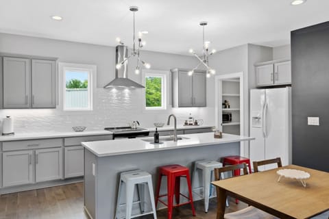 Fully equipped kitchen with stainless steel appliances, a large central island, and modern pendant lighting—ideal for cooking brunch or hosting pre-game drinks