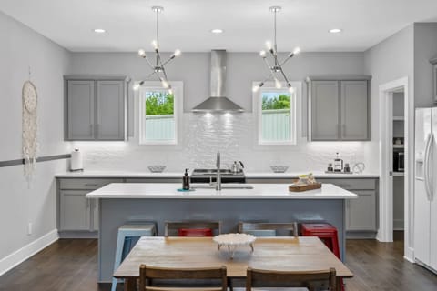 Another view of the open kitchen, highlighting the ample counter space and bar seating that keeps the cook connected to the party.