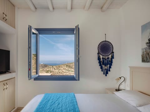 Sunlit bedroom with sea-view window and calming decor.