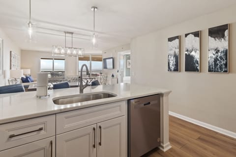 Your open kitchen features sleek countertops and modern appliances, flowing seamlessly into the bright living area where mountain art awaits.
