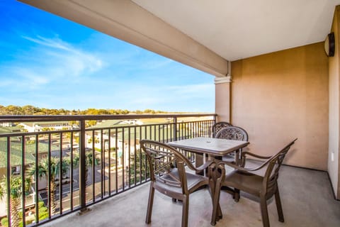 Unwind on your private balcony with comfortable seating while taking in the peaceful neighborhood views under blue skies.