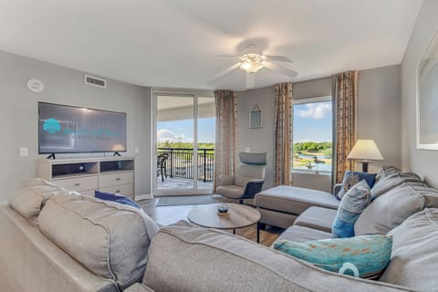 Relax in this bright living room with plush sofas, lake views from your private balcony, and modern entertainment for perfect vacation evenings.