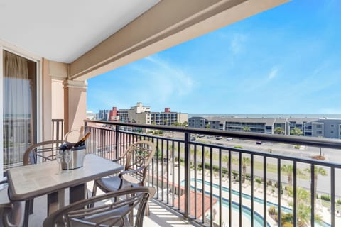 Step onto your private balcony with outdoor dining space and enjoy sweeping views of the pool area and surrounding cityscape.