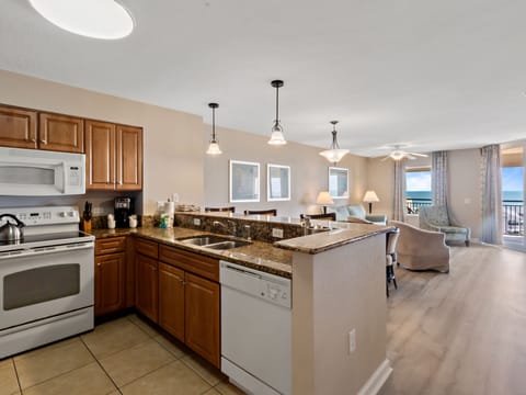Your open-concept kitchen flows seamlessly into the living area, featuring granite countertops and ocean views from your private balcony.