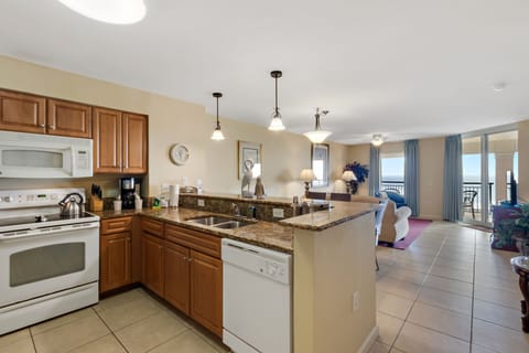 Your spacious kitchen features granite counters and full appliances, flowing seamlessly into the bright living area with stunning ocean views.