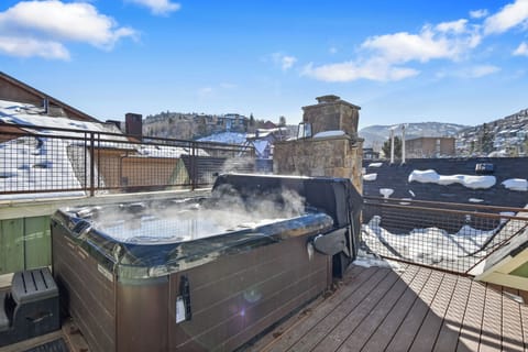 Soak in your private hot tub while winter snow blankets the mountain town around you, creating the perfect alpine getaway.