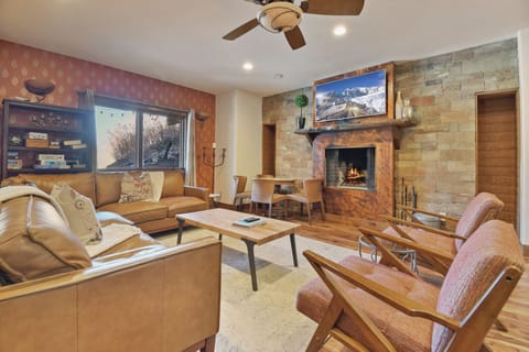 Cozy up by the crackling fireplace in your spacious living area, where leather seating and mountain views create the perfect retreat.