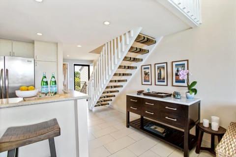 Enjoy cooking in this bright, modern kitchen with stainless steel appliances, sleek stone counters, and soft lighting   