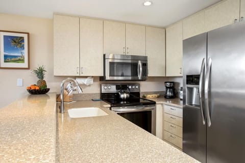 Gather at the bar in this sun-filled kitchen with chic tile floors, soft lighting, and inviting coastal details    