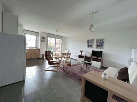 Vue du salon avec canapé, fauteuils et TV HD connectée