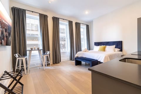 Sunlit king bedroom featuring a comfortable seating area and modern décor.
