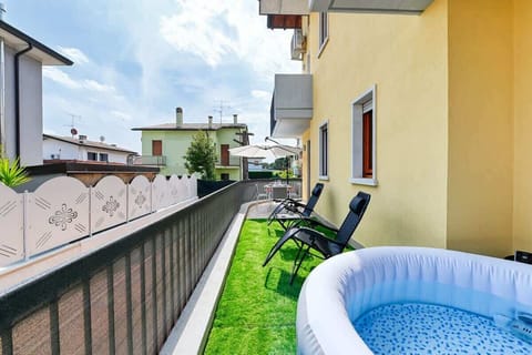 Giardino esterno (NON RECINTATO) con jacuzzi privata, tavolo da pranzo ed ombrellone, sdraio a gravità 0 con erba sintetica