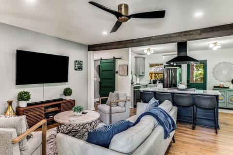 The spacious living room features earthy color tones, modern furniture, and carefully curated details to create a space that is warm and welcoming. Grab a seat on the leather sofa or in one of the two plush armchairs and get comfortable. 