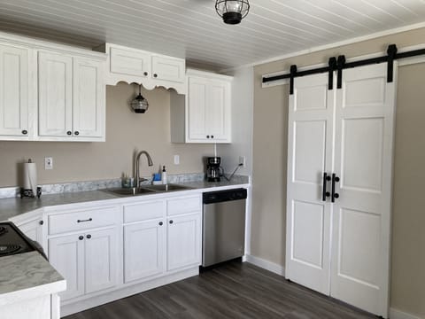 Kitchen with stainless dishwasher and beautiful sliding barn doors