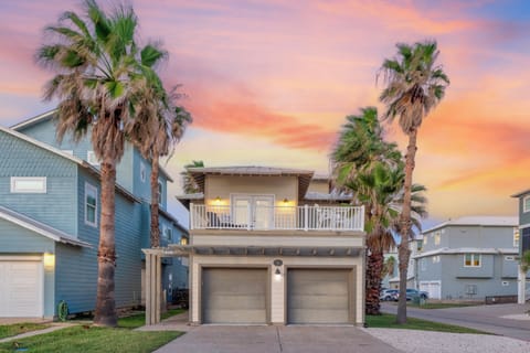 Beautiful coastal property featuring palm trees and stunning sunset skies in a peaceful residential neighborhood.