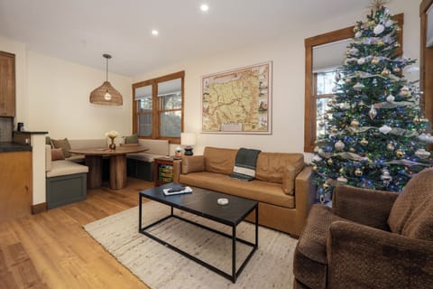 Cozy living and dining space with banquette seating and leather sofa