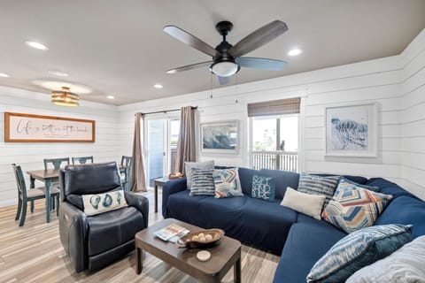 Relax in your open-concept living space with comfortable navy sectional, soft throw pillows, and coastal décor that welcomes you home.