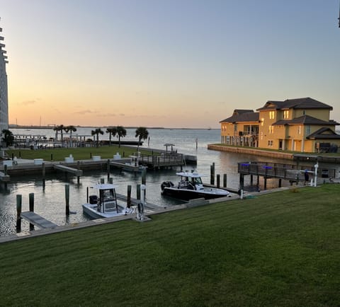 Waterfront marina with boat slips and elegant homes during golden hour sunset.