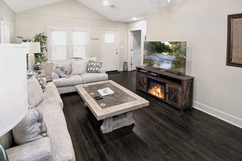 living area with smart TV and fireplace in TV stand.  Video arcade system.
