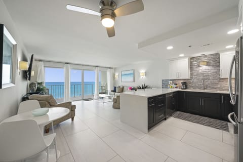Fully renovated beachfront condo at Cabana Club 302 featuring an open-concept kitchen, dining, and living area with stunning Gulf of Mexico views