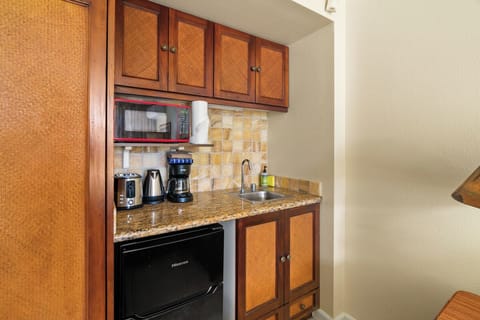 Kitchenette with undercounter refrigerator, microwave, toaster and coffee maker.