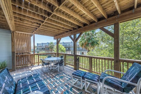 Your spacious covered deck offers perfect outdoor living with comfortable seating and dining areas surrounded by lush greenery.