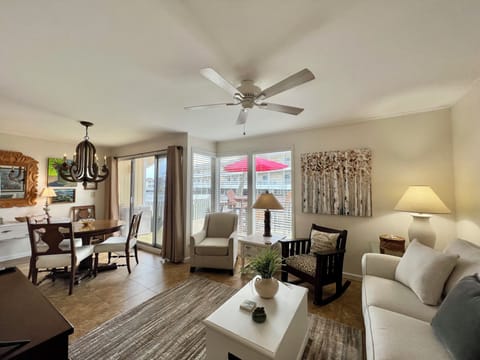 Relax in your bright, open living space where comfort meets style with plush seating and a gentle ceiling fan overhead.