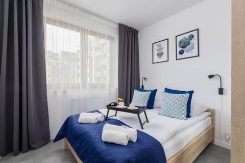 A cozy bedroom with a double bed, navy blue accents, and modern decor, creating a comfortable retreat.
