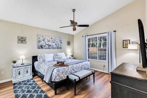 Spacious master bedroom with en suite bathroom, platform king bed with comfortable bedding, walk in closet, ceiling fan, matching nightstands, dresser, 55" HD TV, His/Her vanities and luggage rack.