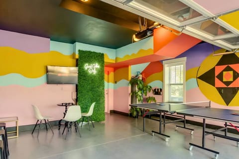 A wildly colorful game room with a ping pong table, bold geometric murals, and botanical wall art is pure fun.