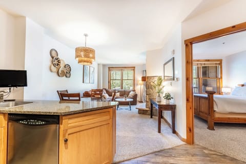 Your open-concept suite flows seamlessly from kitchen to living space, featuring warm wood details and granite counters for memorable meals together.