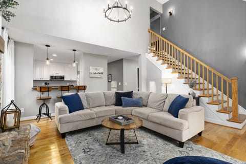 The living room is open to the kitchen, with bar seating for three.