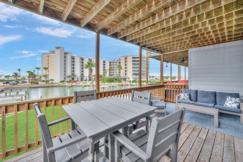 Relax on your waterfront balcony with comfortable seating and dining space overlooking peaceful canals and palm trees.