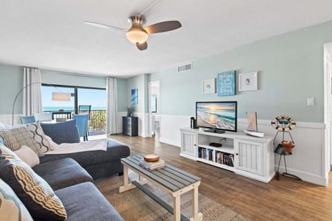 Modern and cozy living room with a comfortable sofa, warm lighting, and balcony access.