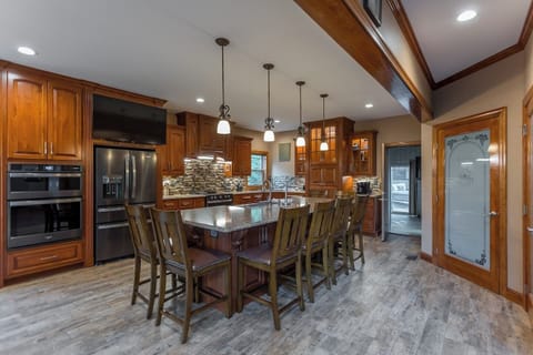 Stunning and incredibly spacious custom kitchen featuring granite counters, a breakfast bar, and a designated dining area.