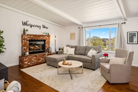 Bright living room with a brick fireplace and airy vaulted ceiling